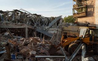 A tractor clears the rubble after a Russian strike on a Kramatorsk hotel which killed a UK citizen