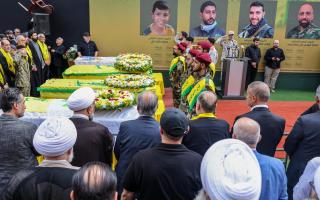 Hezbollah fighters and mourners attend a funeral of people killed after hundreds of paging devices exploded in a deadly wave across Lebanon