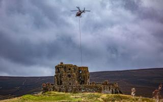 A helicopter making the delivery to Auchindoun Catle