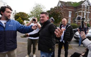 Political activist Tommy Robinson speaks to members of the press outside Folkestone Police Station,